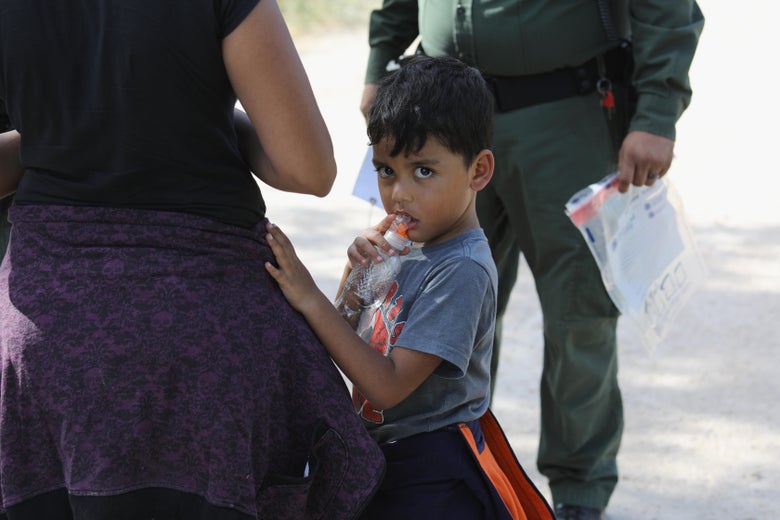 Central American asylum-seekers wait as U.S. Border Patrol agents take them into custody.